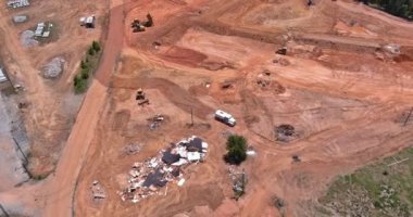 Toprak taşıma ekipmanlarının, ağır makine traktörlerinin kullanıldığı büyük bir inşaat alanının havadan görüntüsü.