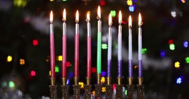 Hanuka bayramı geleneği. Bayram simgeleri. Hanukkiah menoranın mumlarını yakıyor.