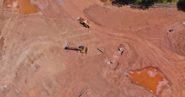 Ağır makineler ve traktörler kullanan büyük inşaat alanının panoramik hava görüntüsü