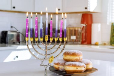 Judaism tradition family religious holiday symbols lighting hanukkiah menorah candles during Hanukkah celebration clipart