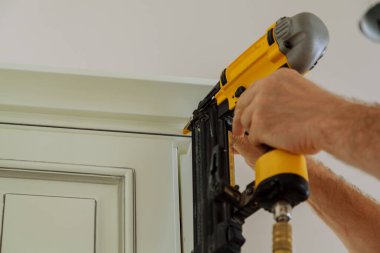 Marangoz brad kullanarak tırnak taç kalıplama silah mutfak dolapları çerçeveleme üzerinde süs, tüm güç araçları üzerinde göstermiştir uyarı etiketi ile emniyet konsepti gösteren