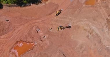 Ağır makinelerin çalıştığı büyük inşaat alanının hava görüntüsü.