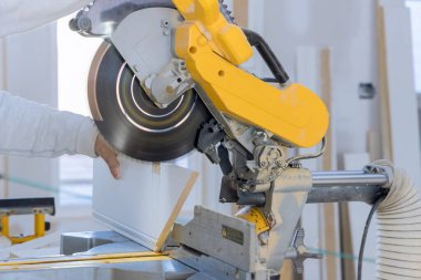 Ahşap döşeme tahtasını bitirmek için, inşaat işçisi yumuşak odaklanmayı kesmek için dairesel testere kullanıyor.