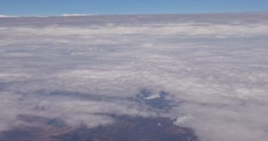 Uçağın penceresinden güzel mavi gökyüzünde beyaz bulutları görebilirsin.