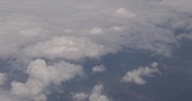 Güzel mavi gökyüzü manzarası ve beyaz bulutlar karadan pencereden bir uçak.