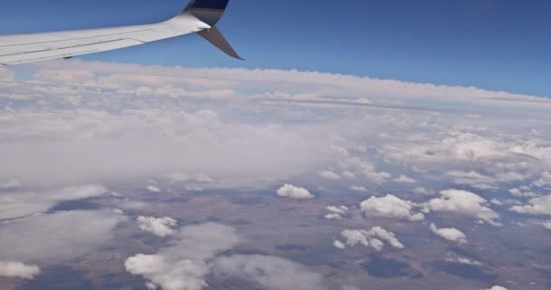 Vleugel Van Een Vliegtuig Vliegen Pluizige Wolken Gezien Door Het — Stockvideo