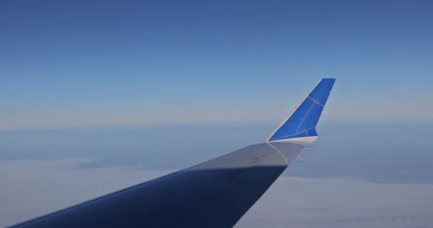 翼翼在云彩之上飞行的飞机翼 通过窗户在蓬松的云彩的背景下看到 — 图库视频影像