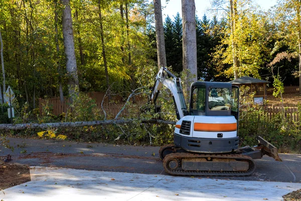 竜巻が木に触れたときに木を根こそぎにして通りに落ち トラクターが破片を除去する必要が生じた — ストック写真