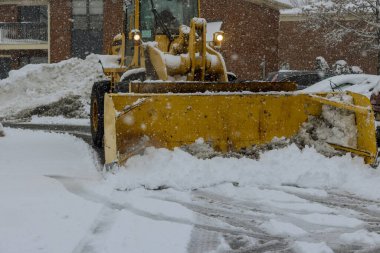 Kar fırtınası kışın şiddetli kar fırtınasından sonra traktörle karları temizler