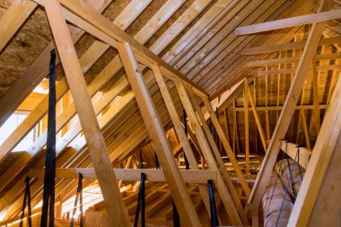 Yeni inşa edilmiş evin tavanında gümüş yalıtım malzemeleriyle havalandırma boruları.