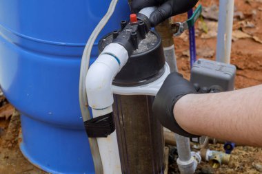 İşçiler su için değiştirilebilir filtrelerin değiştirilmesi de dahil olmak üzere ekipmanlara bakım yaparlar