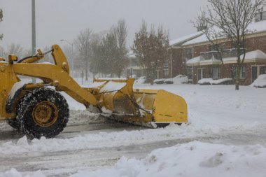 Fırtına sırasında kar temizlemek için büyük bir kar fırtınası traktörü kullanılıyor.