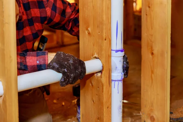 stock image It is plumbing technician gluing PVC pipe to plastic pipe using cement glue for construction residential new home