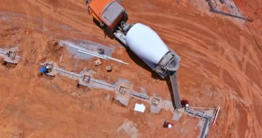 Beton dökme işlemine hazırlanmak için mikser kamyonu kullanıyor. Doğrudan inşaat siperlerine çimento dökülüyor..