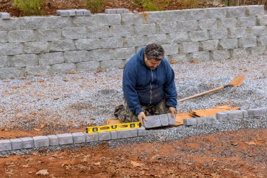 İnşaat işçisinin kaldırım için taş beton kaldırımlar döşemesi