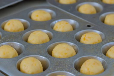 Geleneksel Brezilya atıştırmalık peynirli çöreklerinin hazırlığı ve pişirilmesi evde yapılır.