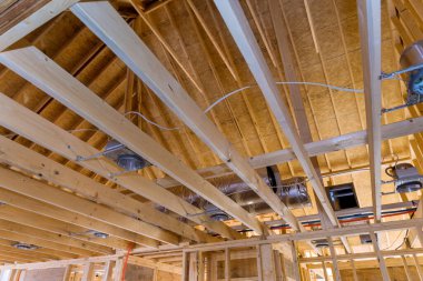 Tavana ve ahşap iskelete monte edilmiş spot lambası olan yeni eve yerleştirilmiş lamba.