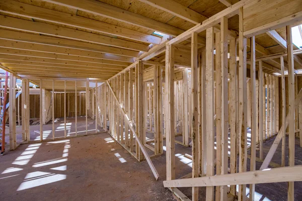 An interior new house under construction with wood framing beams stick framework