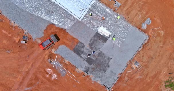 掘削機のバケツは 建設現場に建物のコンクリート基盤を注ぐ前に砂利をレベリングするために使用されています — ストック動画