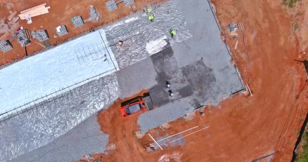 掘削機に取り付けられた建設現場のバケツは 建物の基礎のためにコンクリートを注ぐ前に砂利をレベルするために使用されています — ストック動画
