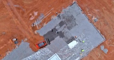 İnşaat alanında inşaatın beton temelleri atılmadan önce çakıl döşemek için bir kazıcı kovası kullanılıyor..