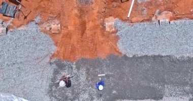 İnşaat sahasında inşa edilen kovaya beton temeli atmadan önce çakıl seviyesini yükseltmek için bir kazıcı kullanılıyor