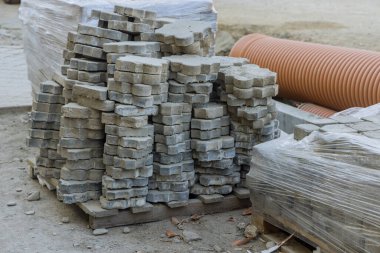 İnşaat, kaldırıma gri beton tuğlalar döşeyen peyzaj kaldırım taşı kurulumunda çalışıyor