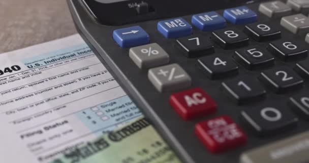 您可以在桌子上看到1040美元的个人所得税收入表 笔头计算器和美国报税表 — 图库视频影像