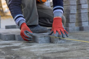 Evin avlusunun kumları üzerinde gri beton döşeme döşeme döşemesi var..
