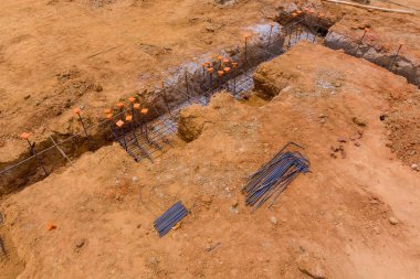 İnşaat alanındaki ev temeli için kısmi hazırlık olarak sipere çelik yerleştiriliyor.