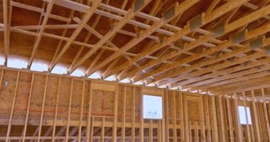 This an interior framing newly constructed house under construction, which is framed with truss beams