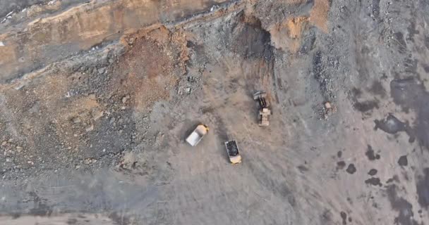 砂利の石の採掘中にダンプトラックに積み込まれて石と採石場で作業中の掘削機 — ストック動画