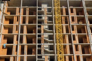 Multi storied apartment building is being constructed along in progress works on construction site