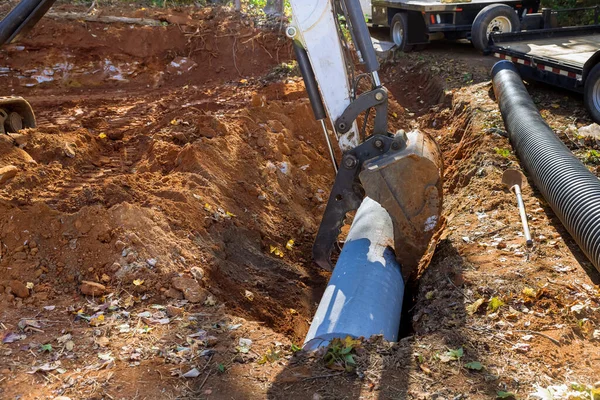 Worker is preparing to install underground concrete pipes that will carry sewage from ground to an underground