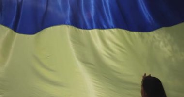 Ukraynalı genç bir kadının Ukrayna bayrağını elinde tutup cennete gitmesi için dua ediyor..