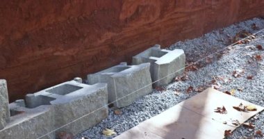 During construction of new home at near construction site construction worker was laying concrete blocks for retaining wall.