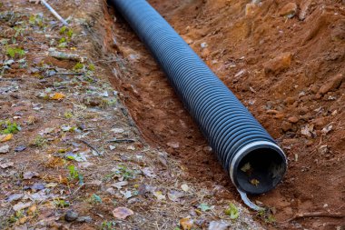Laying for underground installation of PVC sewage black pipes in ground is prevent subterranean flooding.
