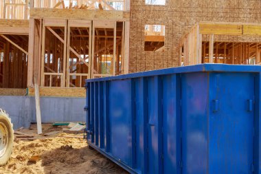 İnşaat alanı, bir sanayi binasının altındaki çöp konteynırı atık imhası için kullanılıyor.