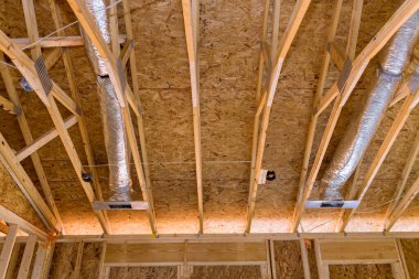 During construction of new stick built home ventilation pipes are installed in silver insulation material on ceiling