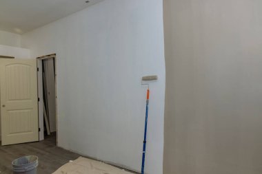 Decorative painted wall with paint equipment near wall of an empty room