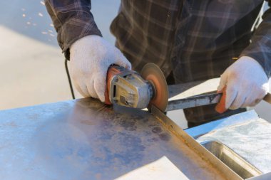 Worker using grinder, for cuts metal with grinder