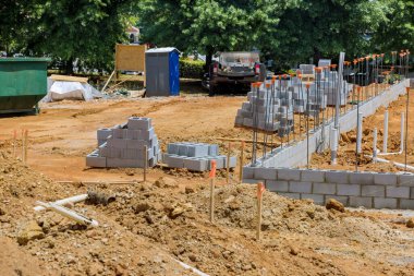 In construction site cement blocks stacked for purpose of being laid on wall house are ready to be laid.