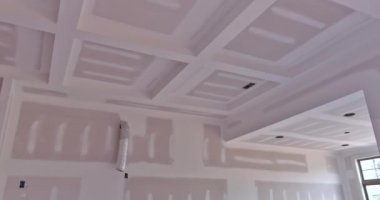 It is time to paint an unfinished house that has just been plastered drywalled by contractor for new home under construction