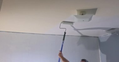 Painted wall with painting equipments and stepladder near wall in empty room