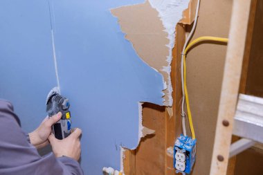 An oscillating multi tool was used to cut off damaged plasterboard part of renovation work in house
