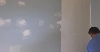 Decorative painted wall with paint equipment near wall of an empty room