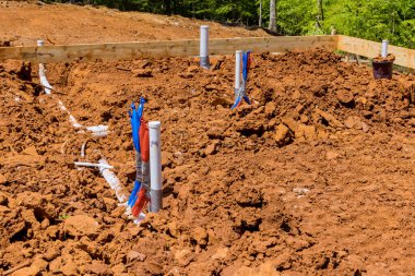 Installing in ground under foundation of new home, laying utilities sewer pipes and water pipes