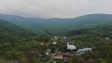 Peaceful morning in mountain with forest and fog above village mountains
