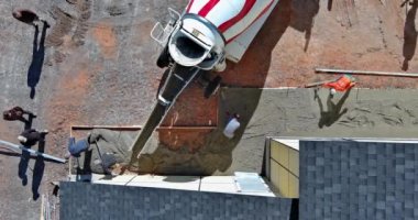 Pavement is being laid around new house with help of concrete mixing truck