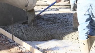 Beton, yeni evin etrafındaki beton karıştırıcı kamyonla kaldırım için dökülüyor.